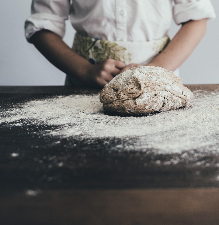 baker laminating dough by hand